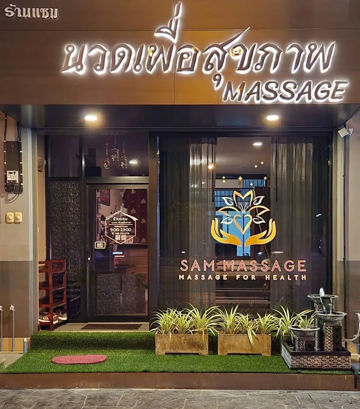 SAM Massage storefront and illuminated sign at night