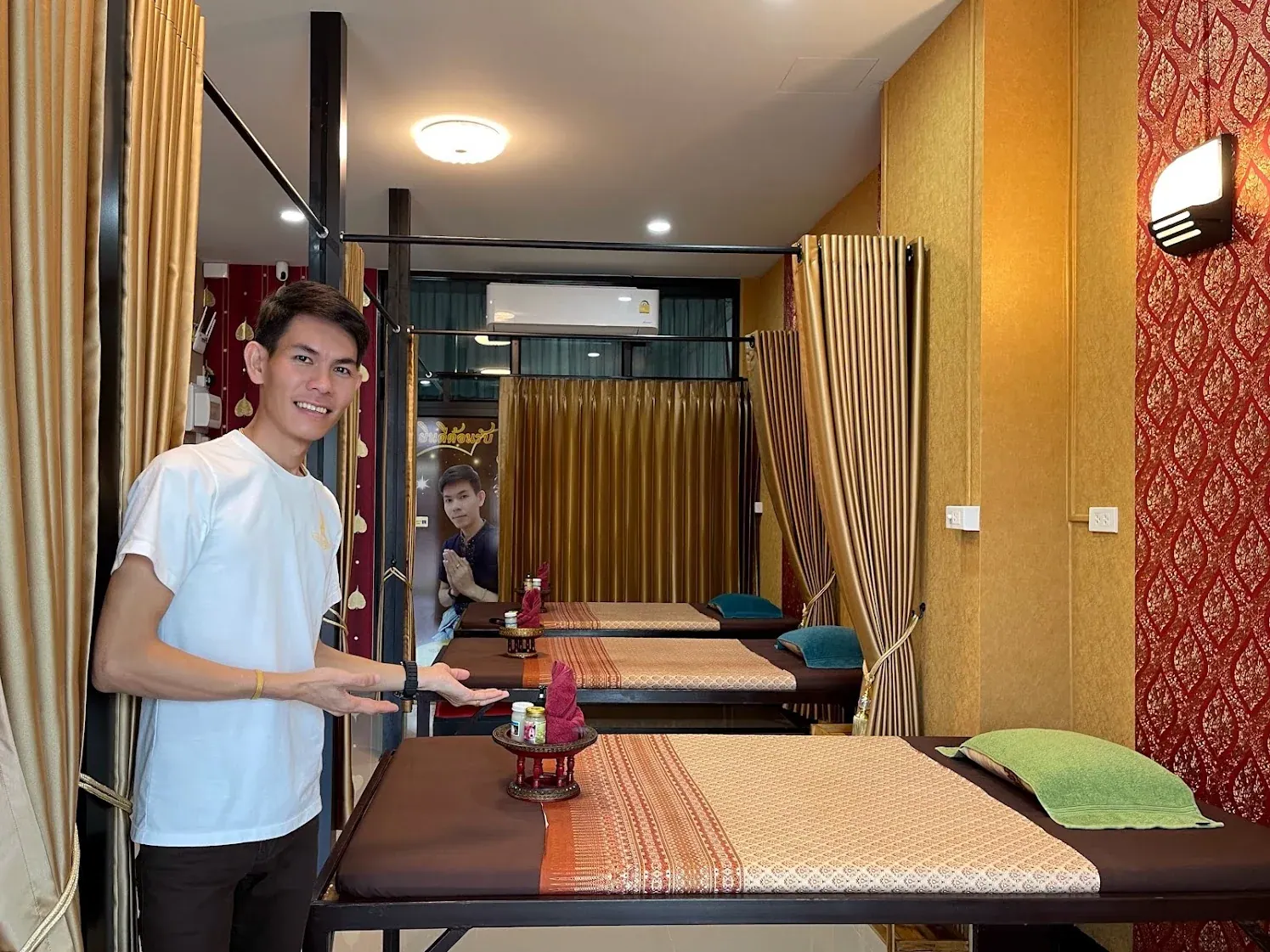 Sam in a white shirt, welcoming guests inside SAM Massage
