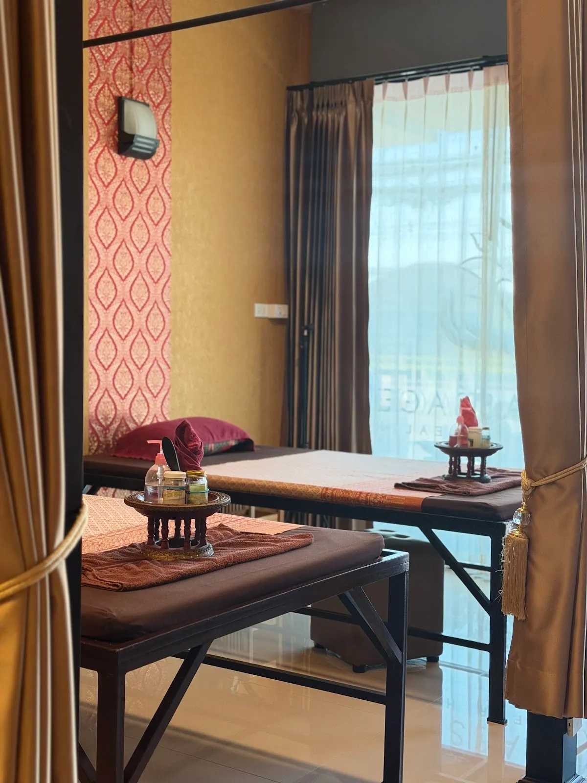 A massage bed beside a window with curtains
